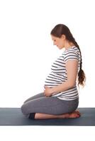 embarazada mujer haciendo yoga asana virasana foto