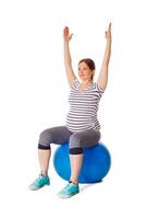 Pregnant woman doing exercises with exercise ball photo