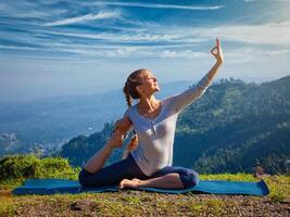 Sorty fit woman doing yoga asana outdoors in mountains photo