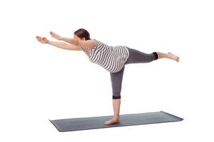 Pregnant woman doing yoga asana Virabhadrasana 3 photo