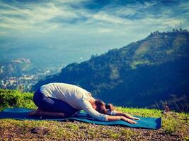 Sporty fit woman practices yoga asana Balasana photo