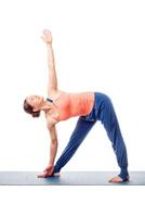 Sporty fit woman practices yoga asana utthita trikonasana photo