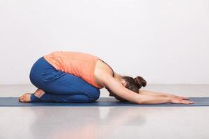 mujer relajarse en hatha yoga asana balasana niño actitud foto