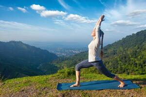 mujer haciendo yoga asana virabhadrasana 1 - guerrero actitud al aire libre foto