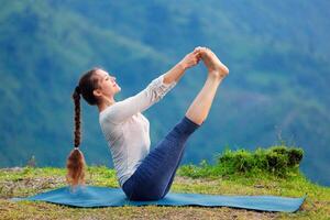 Woman doing Ashtanga Vinyasa Yoga asana outdoors photo