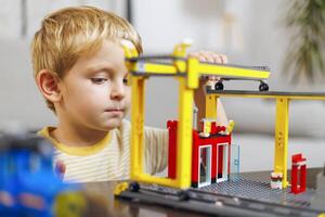 Young Boy Concentrated on Building Toy Construction photo