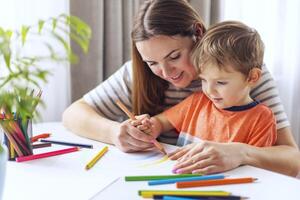 Young Mother Helps Son with Creative Drawing photo