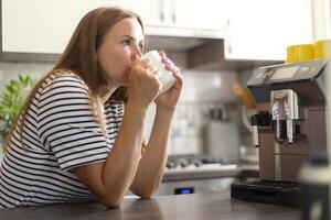 Woman Enjoying Morning Coffee in Modern Kitchen photo
