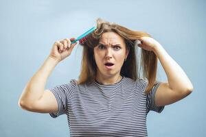 mujer luchando con pelo enredos mientras peinada foto