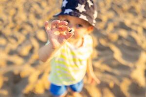 Child holding sea shell on the beach by the sea photo