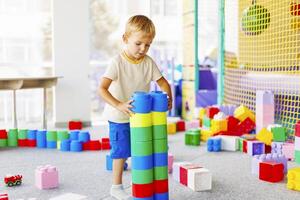 Child playing with colorful building blocks in a playroom setting photo