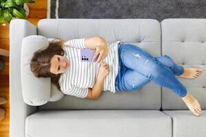 Woman using smartphone surfing social media, checking news, online shopping photo