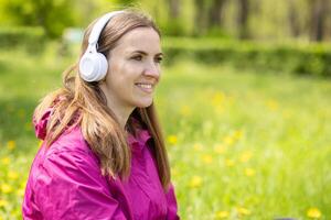 Beautiful young woman likes to listen to music with headphones photo