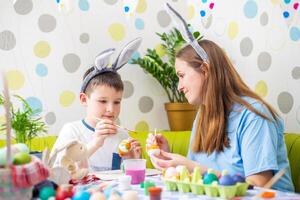 Happy Easter. A mother and her son painting Easter eggs photo