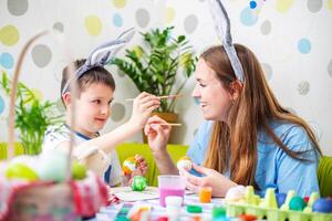 Happy Easter. A mother and her son painting Easter eggs photo