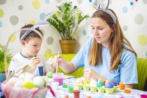 Happy Easter. A mother and her son painting Easter eggs photo