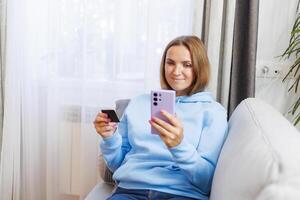 Woman holding credit card and smartphone. photo
