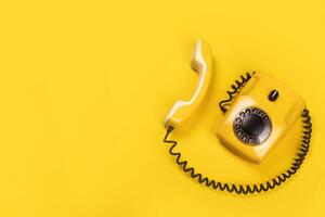 Yellow old stylish Phone, telephone with dial on yellow background copy space for ypur text banner flat lay photo