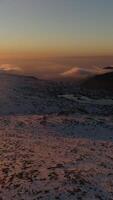 vertical vídeo do neve montanhas às pôr do sol aéreo tiro video