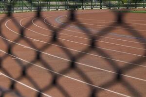 curvas de corriendo pista detrás el cercas deporte antecedentes foto. foto