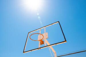 Broken backboard of basketball field in the park. Abandoned town concept photo