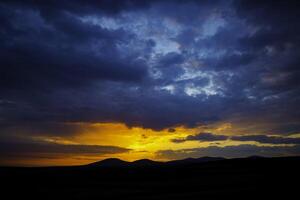 Sunset or sunrise over the hills with dramatic clouds. Peace or heaven concept photo