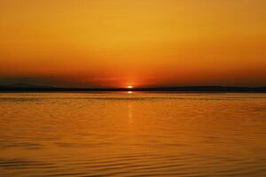 Orange sunset over the lake. Sunset or sunrise background or wallpaper photo