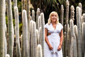 A girl in a white dress on the background of huge cacti on the island of Tenerife.Spain photo