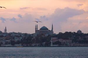 hagia Sofía o ayasofya mezquita a puesta de sol desde kadikoy distrito de Estanbul foto