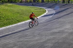 un ciclista con rojo jerseys en el carrera de bicicletas pista para capacitación. foto