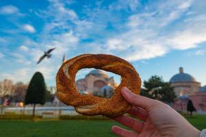 Turkish Bagel or Simit in focus with Hagia Sophia on the background. photo