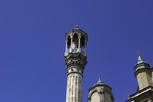 Minaret of Konya Aziziye Mosque isolated on blue sky background photo