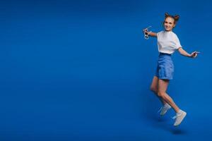 happiness, freedom, motion and people concept - smiling young woman jumping in air over white background photo