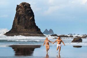 un Pareja de amantes en el arenoso playa de benijo en el isla de tenerife.españa foto