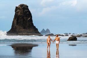 un Pareja de amantes en el arenoso playa de benijo en el isla de tenerife.españa foto