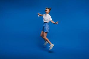 happiness, freedom, motion and people concept - smiling young woman jumping in air over white background photo