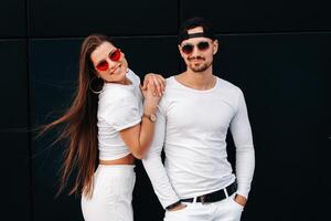 A beautiful couple in love in white stylish clothes are walking in the city photo