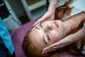 Young woman with beautiful eyebrows after procedure permanent make-up in salon photo