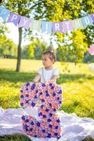 alegre niña teniendo divertido en niño cumpleaños en cobija con papel decoraciones en el parque foto