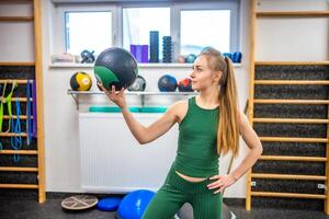 Portrait of young woman fitness instructor with ball in her hand photo