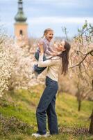 Young mother and her cute daughter having a fun in spring time park Petrin in Prague, Europe photo