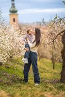 joven madre y su linda hija teniendo un divertido en primavera hora parque petrin en praga, Europa foto