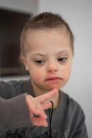 Portrait of small boy with down syndrome in home bedroom. High quality photo