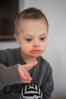 retrato de pequeño chico con abajo síndrome en hogar dormitorio. alto calidad foto