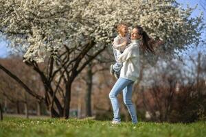 Young mother and her cute daughter having a fun in spring time park in Prague, Europe photo