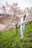 Lovely young woman in a blooming pink and white garden Petrin in Prague, spring time in Europe. High quality photo