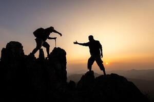 Silhouette of The men helping pull people up from high cliffs. photo