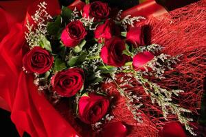 a bouquet of red roses is wrapped in red photo