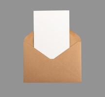 Postcard, vertical card mock up, clean paper sheet from open kraft envelope isolated on white photo