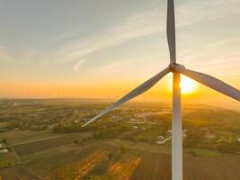 Wind farm field and sunset sky. Wind power. Sustainable, renewable energy. Wind turbines generate electricity. Sustainable development. Green technology for energy sustainability. Eco-friendly energy. photo